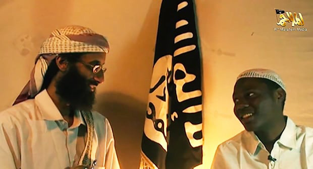 two men smiling with a flag between them